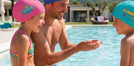Famiglia in piscina con cuffie da nuoto Gheddi personalizzate in poliestere Gheddi